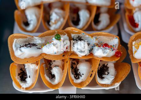 Délicieux dessert Kanom Thai street, Buang, Thai Thai ou crêpe croustillante crêpe, avec des variétés d'obturations comme crème anglaise blanc doux et doré Banque D'Images