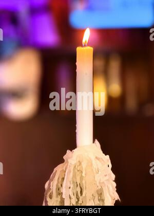 Bougie et flamme avec une accumulation de cire fondue Banque D'Images