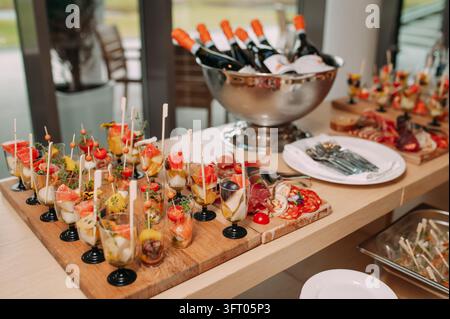 Table de buffet élégante avec des hors-d'œuvre gastronomiques et du vin pétillant Banque D'Images