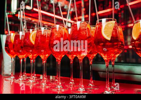 Cocktails rouges avec glace et tranches de citron dans un bar élégant Banque D'Images
