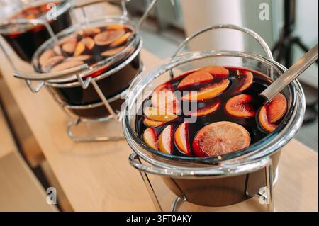Vin chaud avec des tranches d'orange et de pomme à un buffet Banque D'Images
