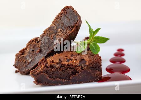Une magnifique prise de vue en gros plan sous angle élevé d'un plateau de dessert décadent mettant en vedette deux brownies au chocolat riches et fondants empilés soigneusement et garnis de Banque D'Images