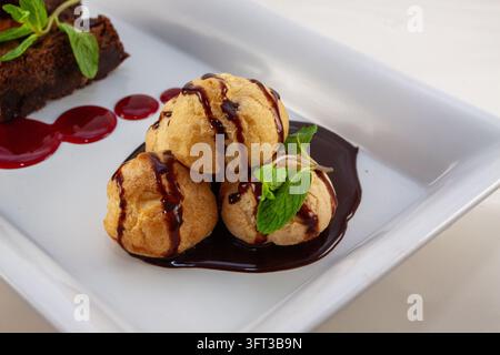 Une photographie alimentaire horizontale large en studio capturant un échantillon de dessert double luxueux présentant deux brownies au chocolat riches et fondants et une petite pyramide o Banque D'Images