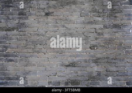 Cette texture haute résolution présente un mur de briques gris vieilli avec des surfaces rugueuses et irrégulières et un mortier de ciment érodé visible entre chaque brique. Le Banque D'Images