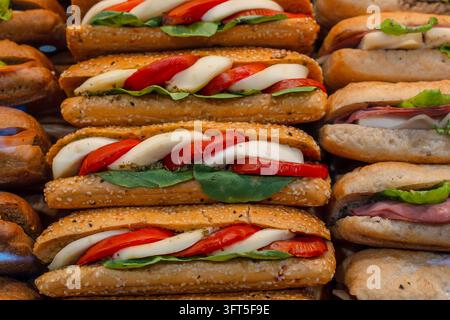 Sandwiches frais avec tomates et fromage mozzarella exposés sur un comptoir. Banque D'Images