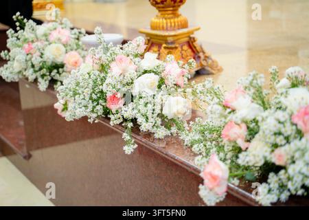 Arrangement de fleurs fraîches de roses blanches et roses sur l'autel de l'église Banque D'Images