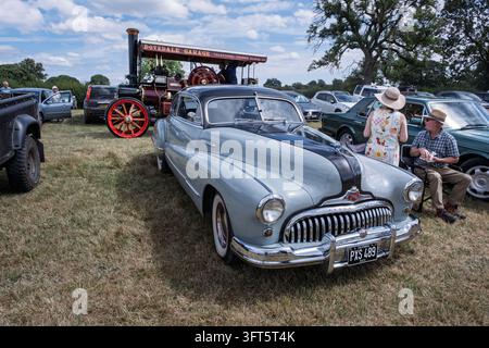 Les propriétaires d'une Buick Eight américaine classique regardent une locomotive à vapeur passer lors d'un rallye vintage, Tissington, Derbyshire Banque D'Images