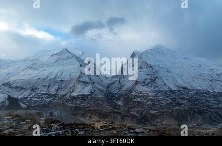 Vue aérienne du fort de Baltit niché contre les pics enneigés spectaculaires de la chaîne du Karakoram dans la vallée de Karimabad, Hunza, Pakistan Banque D'Images