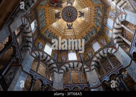 DOME EN MOSAÏQUE OR INTRICATE, CATHÉDRALE D'AACHEN, AACHEN, ALLEMAGNE : Un regard direct vers le haut sur la mosaïque dorée étonnamment détaillée du dôme octogonal du plafond de la cathédrale ancienne historique. INFO : La cathédrale d'Aix-la-Chapelle, le premier site du patrimoine mondial de l'UNESCO en Allemagne, est un chef-d'œuvre architectural carolingien fondé par Charlemagne. Fusionnant des éléments byzantins et gothiques, ce monument historique a servi de lieu de couronnement à trente et un monarques allemands. Banque D'Images