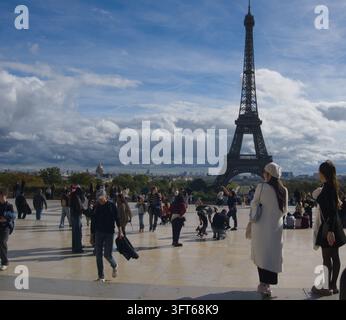 Touristes et visiteurs rassemblés sur l'Esplanade du Trocadéro profitant de la vue sur la Tour Eiffel sous un ciel partiellement nuageux à Paris, France. Banque D'Images
