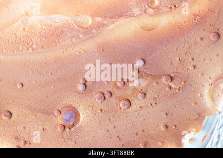Fond macro abstrait d'art fluide scintillant présentant des teintes de cuivre et de bronze avec de petites bulles métalliques et une texture liquide Banque D'Images
