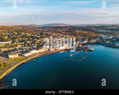Vue aérienne de la ville côtière d'Oban avec son port, ses bateaux et ses bâtiments historiques nichés le long de la baie sous un ciel bleu clair à Oban, en Écosse Banque D'Images
