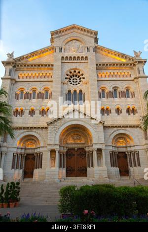 Vue verticale à faible angle de la façade romane-byzantine illuminée de la cathédrale Saint-Nicolas au crépuscule avec des fleurs décoratives au premier plan i Banque D'Images