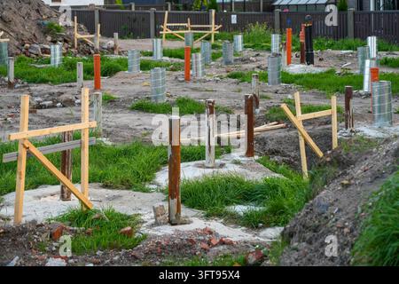 Chantier de construction modulaire montrant des pieux de fondation en acier, des bases en béton, des supports isolés et des tuyaux d'utilité préparés pour une maison préfabriquée Banque D'Images