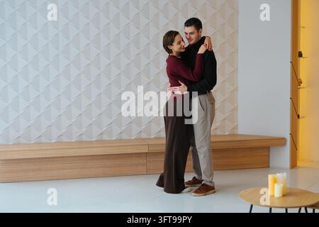 Couple profitant d'un moment tendre dans un cadre intérieur moderne Banque D'Images
