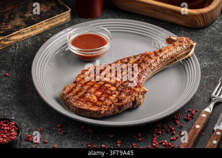 Steak tomahawk grillé avec sauce barbecue Banque D'Images