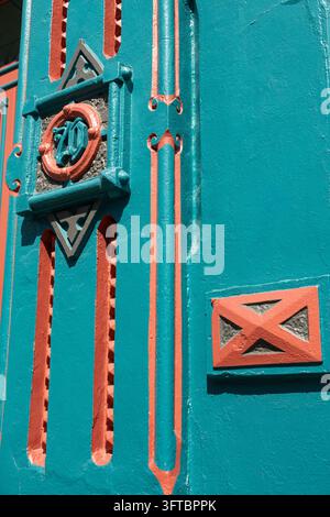 Gros plan des détails architecturaux décoratifs sur un bâtiment historique à Galveston, Texas, États-Unis. Reliefs peints en bleu-vert et rouge terre cuite, géométriques Banque D'Images