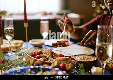 Femme noire servant du poulet rôti lors d'un dîner festif de fête Banque D'Images
