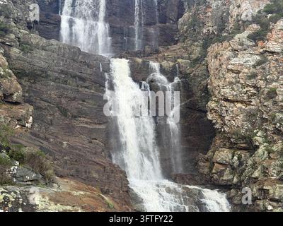 Cascade haute dévalant sur les roches sombres de Tsitsikamma, photographiée à l'embouchure de la rivière Storms dans le parc national de Tsitsikamma, en Afrique du Sud. Banque D'Images