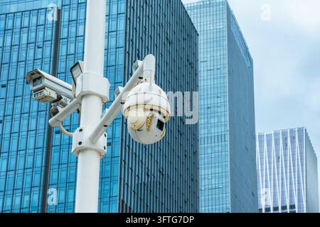 Caméras de surveillance CCTV sur poteau devant des bâtiments de bureaux modernes dans la ville de Shenzhen, Chine. Sécurité urbaine, surveillance vidéo, sécurité publique, smart Banque D'Images