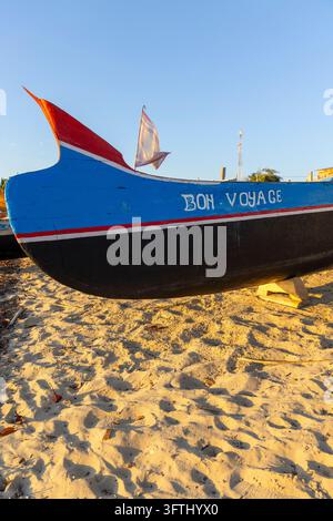 Proue colorée d'un bateau de pêche en bois peint avec les mots Bon Voyage reposant sur le sable, Menabe, Belo sur Mer, Madagascar Banque D'Images