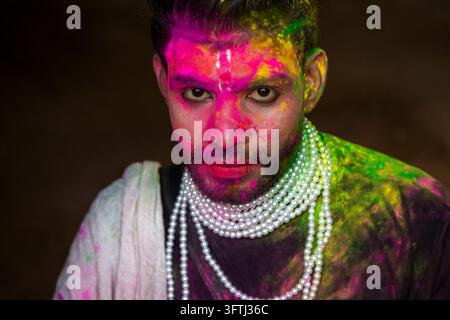 Portrait en gros plan d'un homme barbu avec de la poudre rose sur le visage portant des colliers de perles au Lathmar Holi, Uttar Pradesh, Barsana, Inde Banque D'Images