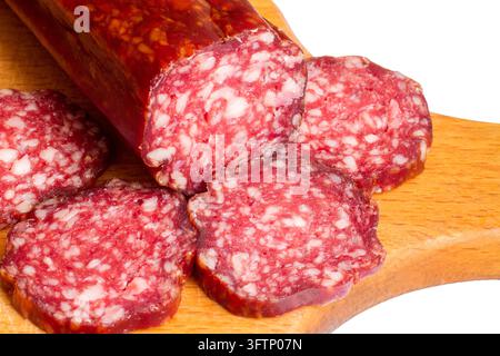 Tranches de saucisse fumée en gros plan. Saucisse de viande naturelle sur une planche à découper. Saucisse sur fond blanc. Banque D'Images