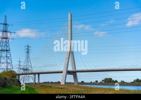Vue du pont de Flintshire avec son grand pylône et ses câbles en acier, se détachant sur un ciel bleu clair avec des pylônes électriques à l'arrière-plan près de la rivière Banque D'Images