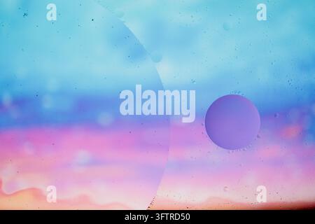 Photographie macro abstraite époustouflante de gouttelettes d'huile formant des cercles géométriques distincts sur un fond dégradé pastel onirique Banque D'Images