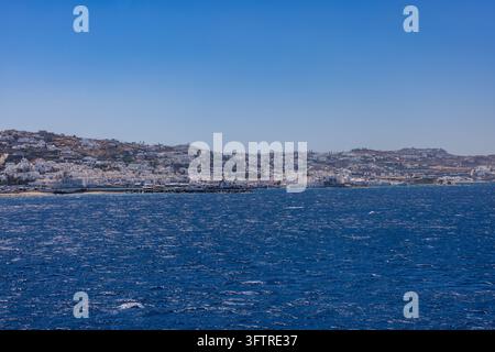 Vue panoramique de la ville de Mykonos depuis la mer, mettant en vedette l'architecture cycladique blanche emblématique, le moulin à vent historique sur la colline et le vibrant Banque D'Images