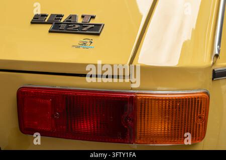 GANDIA, ESPAGNE - 4 OCTOBRE 2026 : Gros plan du feu arrière et de l'emblème logo sur une automobile vintage SEAT 127 jaune classique. Banque D'Images