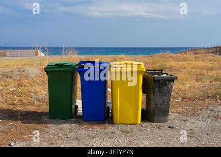 Bennes de recyclage colorées sur la plage au bord de la mer, concept de tri des déchets Banque D'Images