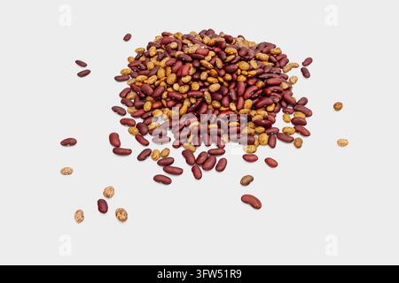 Vue aérienne de haricots rouges mélangés et de haricots pinto tachetés éparpillés sur fond blanc, légumineuses sèches brillantes en tas avec a3 Banque D'Images