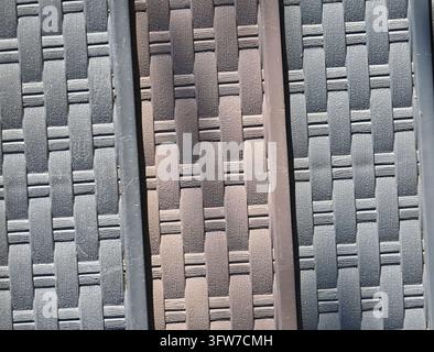 Photographie mettant en valeur la texture et le motif en gros plan d'un tissage en rotin synthétique sombre utilisé pour les meubles d'extérieur modernes Banque D'Images