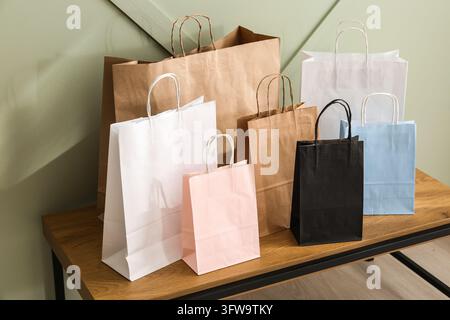 Achat et consumérisme, collection de sacs en papier colorés sur une table en bois pour le marketing de détail et le concept d'emballage durable Banque D'Images