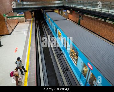 SANTIAGO, CHILE - 10 DÉCEMBRE 2025 : Un train bleu du métro entre dans les quais souterrains de la station Santa Ana à Santiago, au Chili Banque D'Images