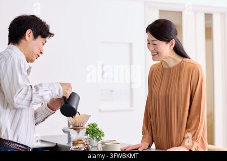 Couple japonais profitant d'un moment de paix avec une tasse de café fraîchement préparée Banque D'Images