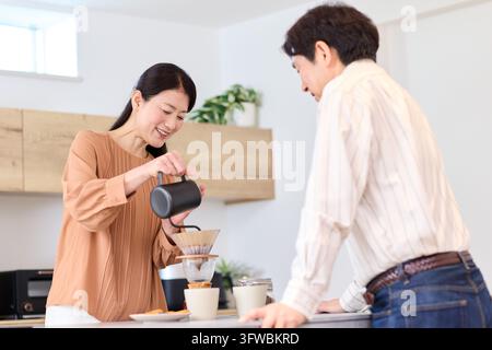 Couple profitant d'un café dans leur cuisine Banque D'Images