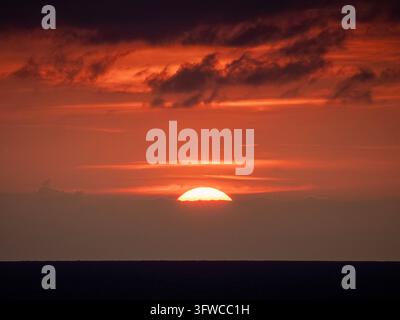 Couchant doré orange sur l'océan Atlantique avec des nuages épars, vu depuis une ferry traversant entre l'Espagne et Plymouth. Banque D'Images