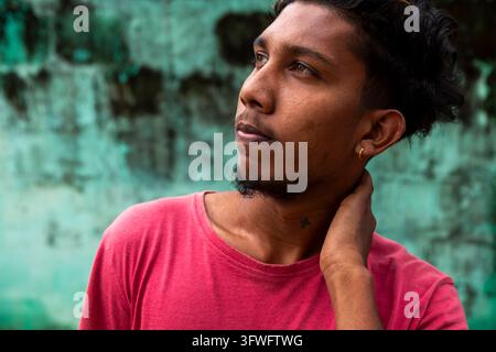 Jeune homme en t-shirt rouge regardant au loin, Province du Nord, Jaffna, Sri Lanka Banque D'Images