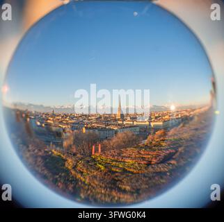 Vue du monument Mole Antonelliana dominant la skyline historique de Turin, avec les Alpes enneigées en arrière-plan, vue à travers une boule de cristal Banque D'Images