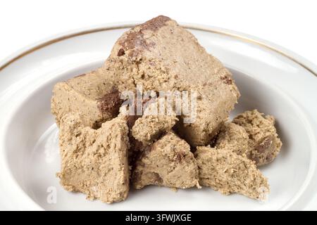 Halva sucrée dans une assiette. Confectionnerie en gros plan sur fond blanc. Banque D'Images