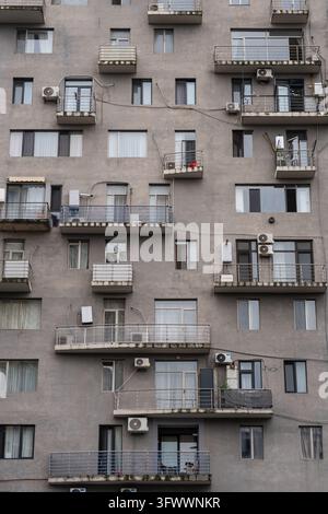 Immeuble d'habitation en béton avec des trous de perçage désordonnés dans les murs de la façade à Batumi. Banque D'Images