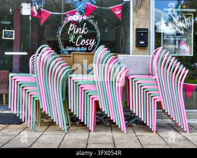 Piles de chaises de café roses et vert pâle sur la terrasse du café / salon de thé "Pink & Cosy" - La Roche Posay, Vienne (86), France. Banque D'Images