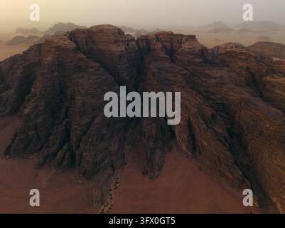 Vue aérienne des montagnes de grès escarpées et des dunes de sable rouge du désert de Wadi Rum dans le gouvernorat d'Aqaba, Jordanie. Banque D'Images