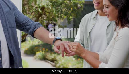 Échange de bagues, couple célébrant leurs fiançailles en plein air dans un cadre de jardin magnifique. célébration, romance, bonheur, amour, engagement, occasion spéciale Banque D'Images
