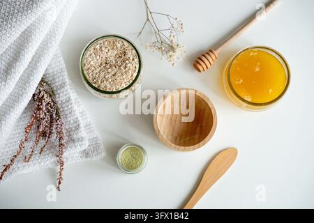 Vue du dessus des ingrédients naturels pour un masque pour le visage DIY comprenant de l'avoine, du miel et de la poudre d'argile. Cette composition met l'accent sur les soins organiques de la peau, le bien-être, Banque D'Images