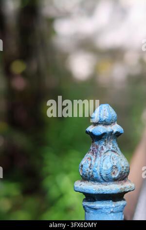Grossissement d'un ancien sommet de clôture en fonte peint en bleu avec une texture patinée Banque D'Images