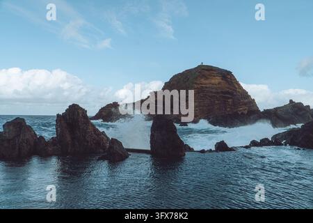 Vagues dramatiques s'écrasant dans les bassins de baignade naturels volcaniques de Porto Moniz, Madère, Portugal. Banque D'Images