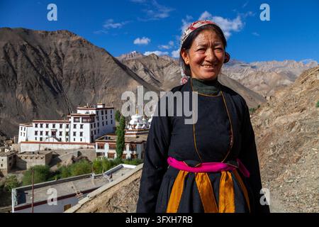 Femme souriante en tenue traditionnelle debout devant le monastère de Yuru, Ladakh, Lamayuru, Inde Banque D'Images